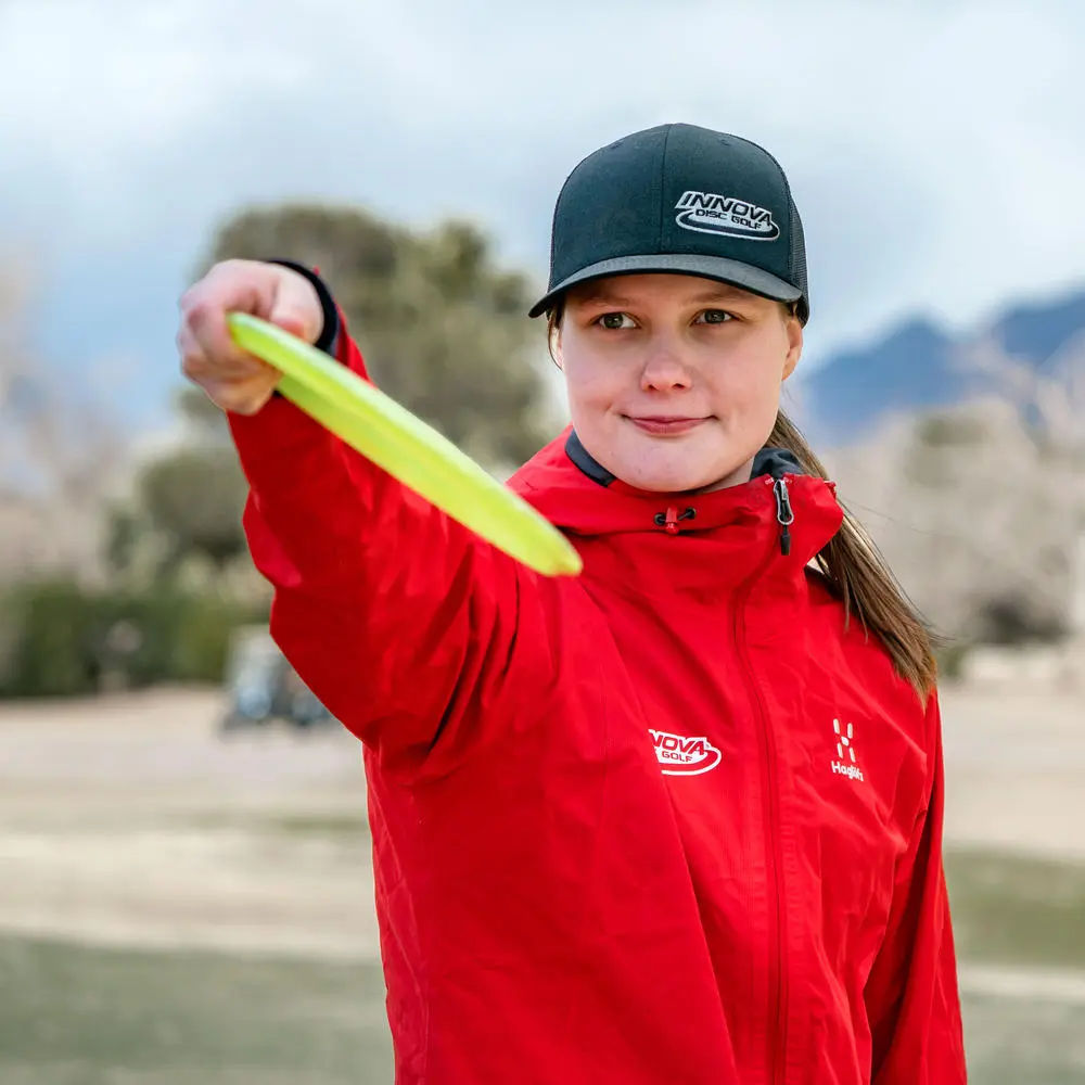 Hyzer vs Anhyzer: Disc golfer Henna Blomroos demonstrating a hyzer release angle for a backhand throw.