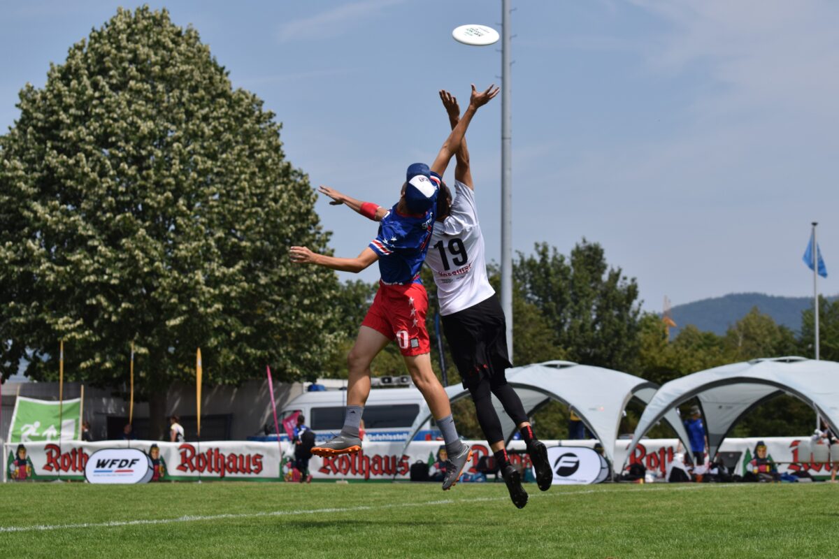 Ultimate Frisbee players jumping to reach the disc in the air.