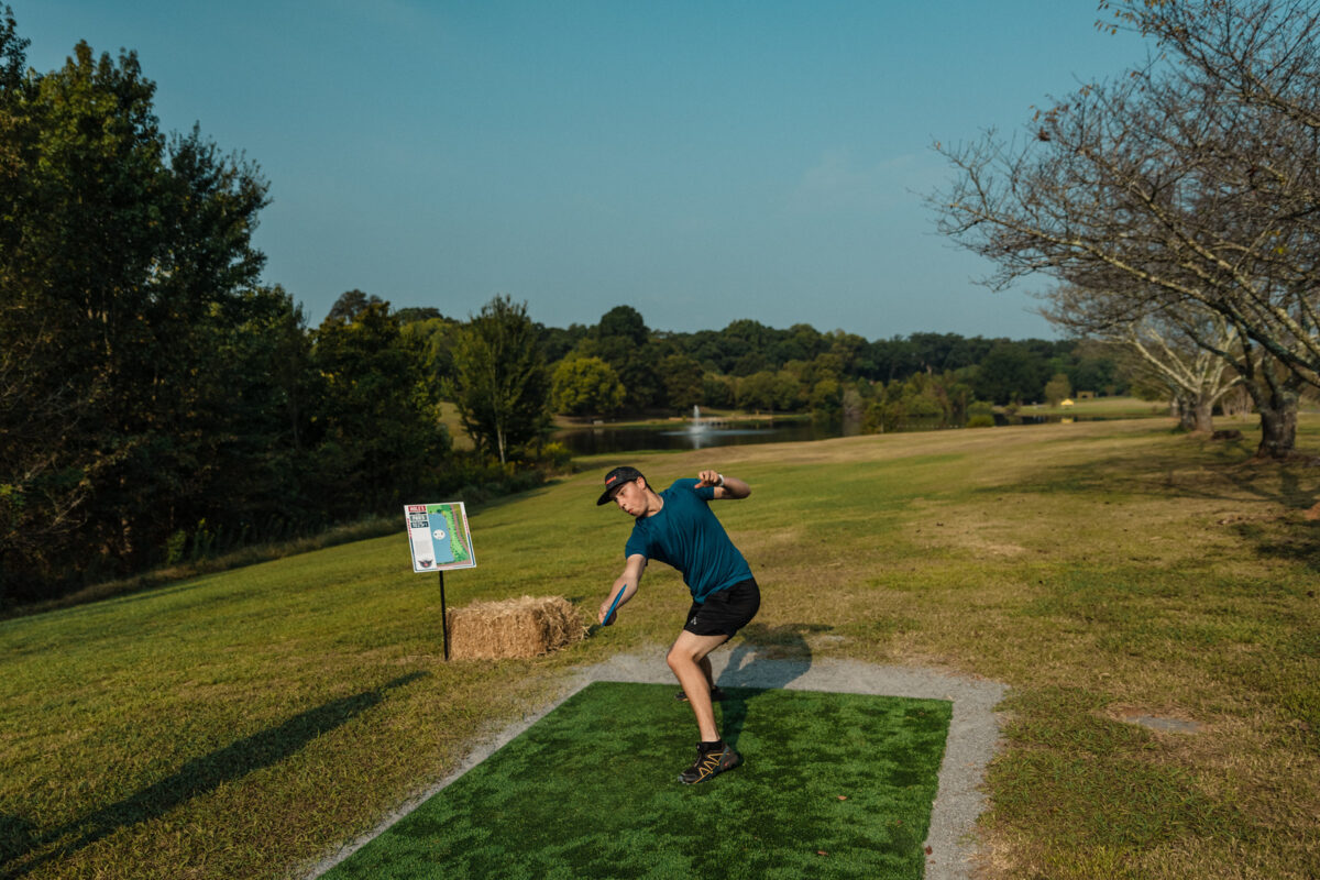A player at the US Disc Golf Championships drives from a artificial turf tee pad. 