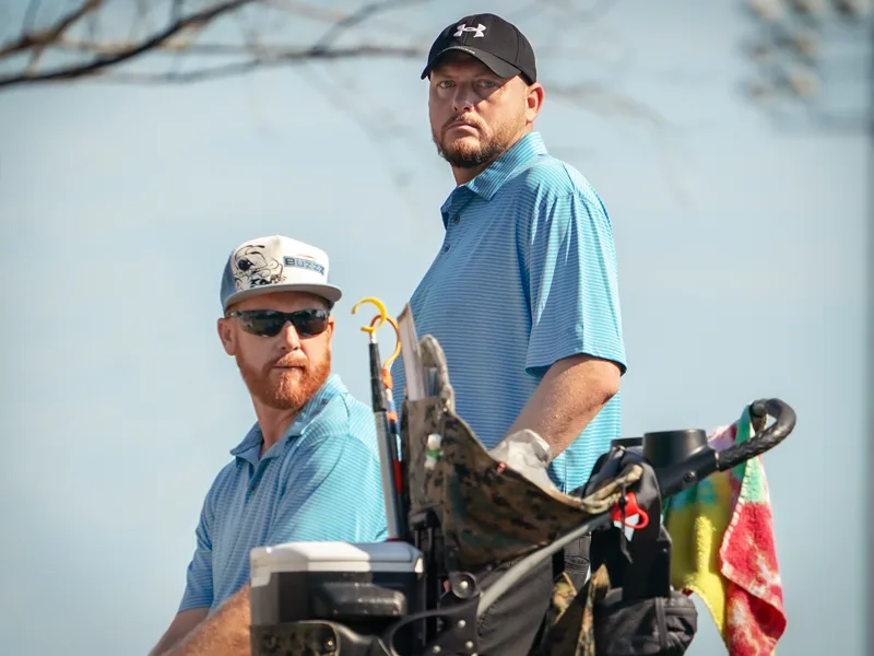 Variations of disc golf. A disc golf doubles team waits for their next shot.